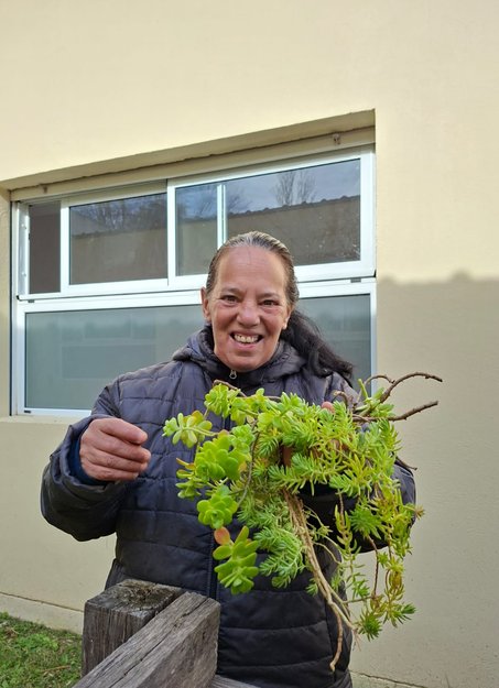 Concurrente de Espacio Encuentro con una planta en el patio de la institución